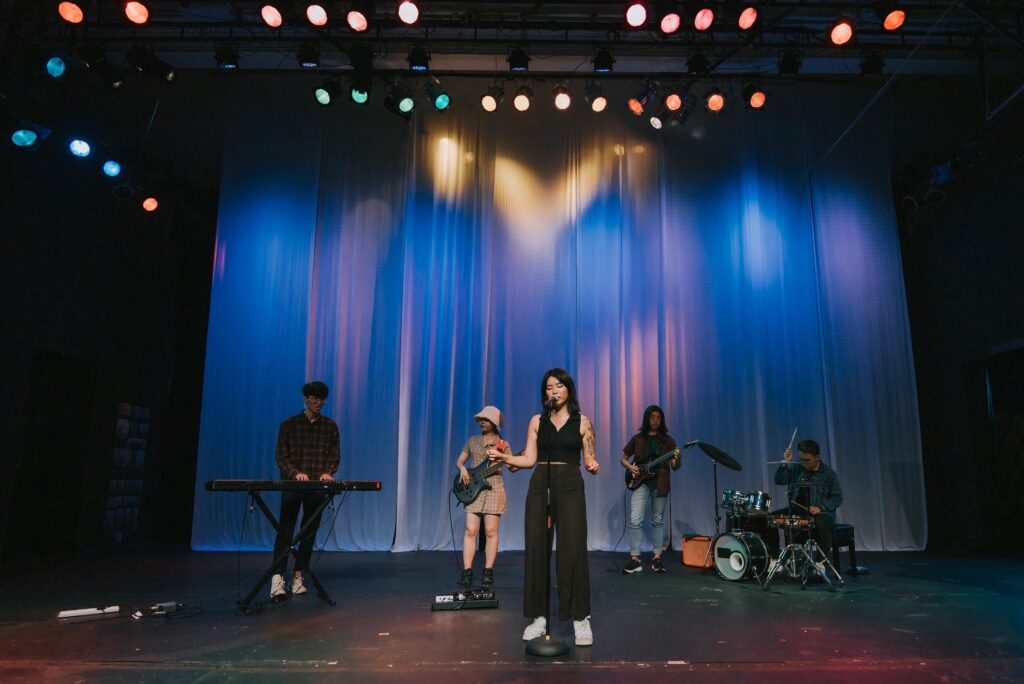 Young Asian chinese lead singer and live band Multiracial group performance on stage
